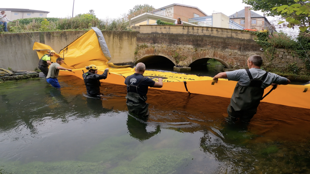 Équipe installant un batardeau souple Water-Gate© dans la rivière Valmont à Fécamp avant fermeture progressive du bras secondaire.