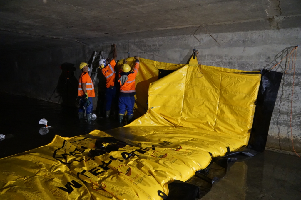 Équipe installant un batardeau souple Water-Gate© dans un ouvrage hydraulique souterrain en béton à Cagnes-sur-Mer.