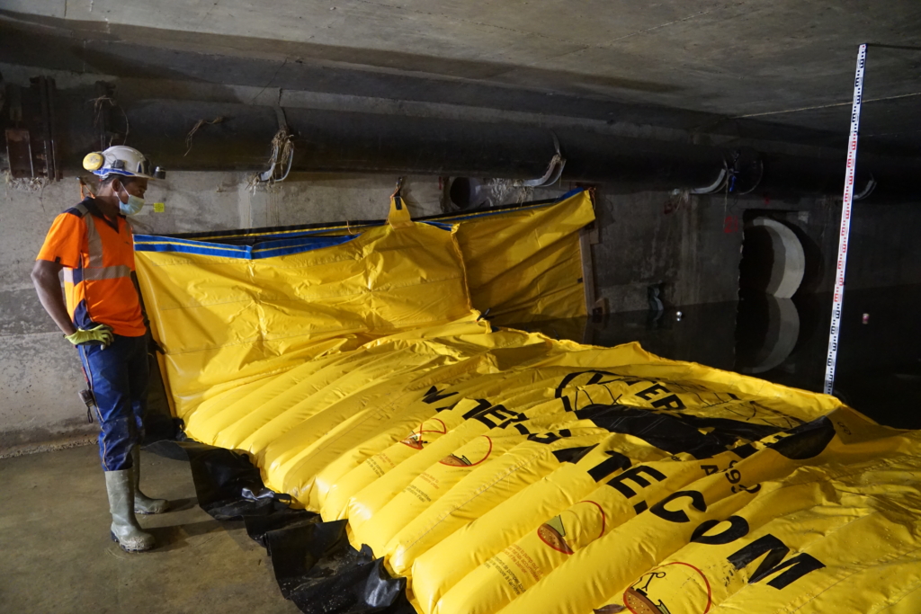 Technicien contrôlant un batardeau souple Water-Gate© installé dans un cadre béton souterrain à Cagnes-sur-Mer.