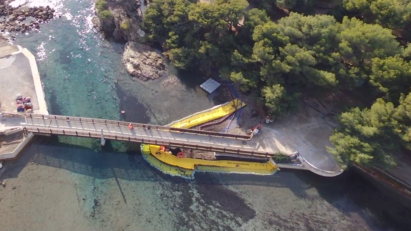 Vue drone du dispositif de batardeaux souples installé autour de la passerelle du Gaou pendant les travaux en lagune marine.